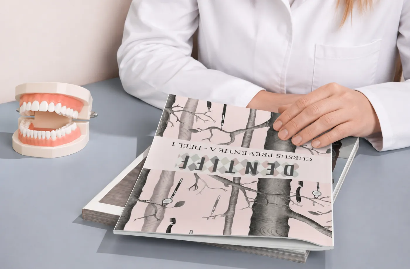 Cursusboek Dentiff Preventie A op tafel naast een gebitsmodel